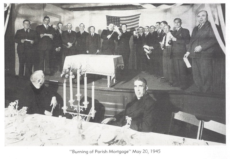 The man in front of the flag onstage holding the candle to the document is Archbishop Ioan (John) Teorodovych of the American Ukrainian Orthodox Church in the United States