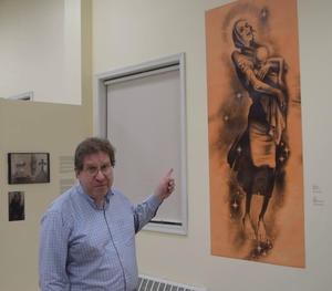 UHEC archivist Micheal Andrec points towards a reproduction of Cymbal's "The Year 1933"
